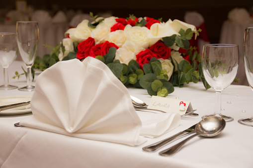 Wedding table place setting with flowers and a decorated napkin