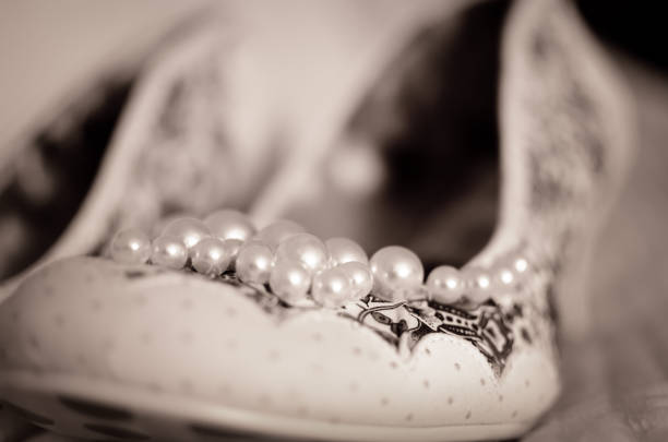 Monochrome closeup image of a wedding shoe with pears.