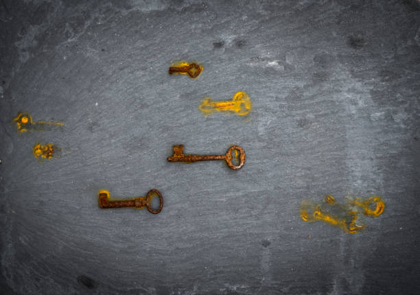 keys with rust marks photographed from above on a black stone background