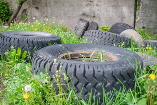 istock Old car tires lying among green the grass. Environmental pollution. 1222607959