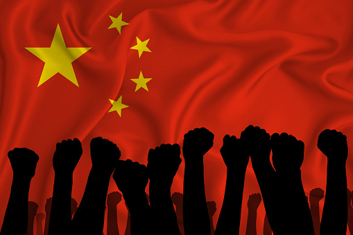 Silhouette of raised arms and clenched fists on the background of the flag of china. The concept of power, power, conflict. With place for your text.