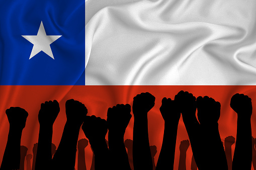 Silhouette of raised arms and clenched fists on the background of the flag of Chile. The concept of power, power, conflict. With place for your text.