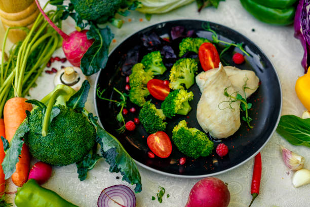 Boiled chicken breast with broccoli and tomatoes on a decorated table