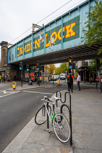 LONDON - SEPTEMBER 30, 2019: Tall shot of the famous Camden Lock bridge on Camden High Street with the painted sign clearly visible and a bike in the foreground