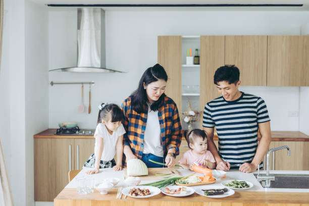 Family Making Dinner Together Asian Family preparing food together in the kitchen taiwan people stock pictures, royalty-free photos & images