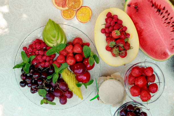 istock berries and fruit in a transparent plate. Apples, pears, cherries, raspberries, plums, grapes. 1222620504
