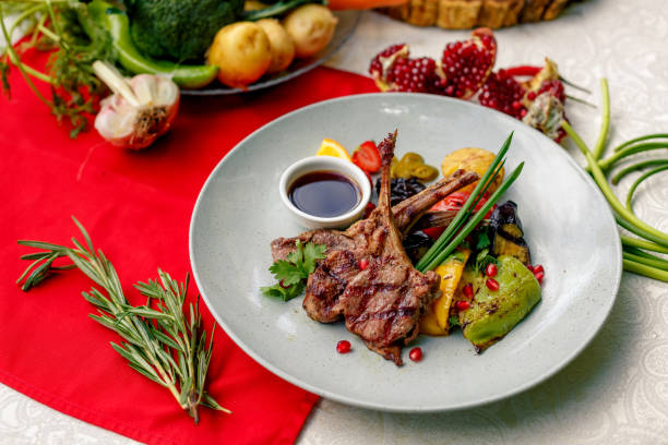 istock Grilled meat with vegetables and sauce on a white plate 1222620704