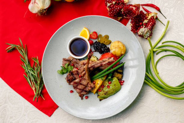 istock Grilled meat with vegetables and sauce on a white plate 1222621225