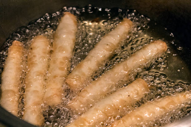 istock Turkish cigarette rolls pastries, being fried in liquid oil. 1222621794