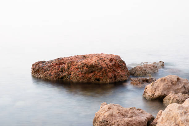 Rocks on the shore of Didim Turkey and with calm waters.