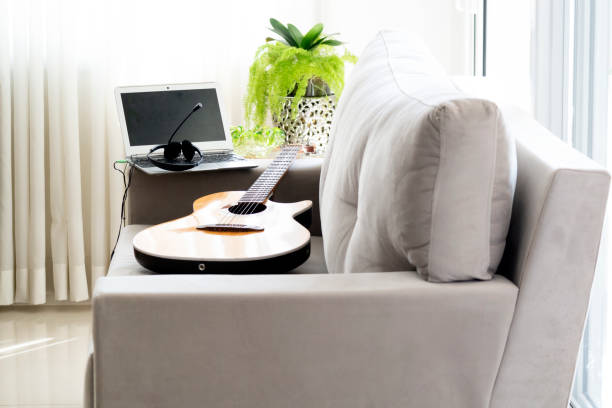 istock A guitar and a laptop over a velvet sofa. 1222623206
