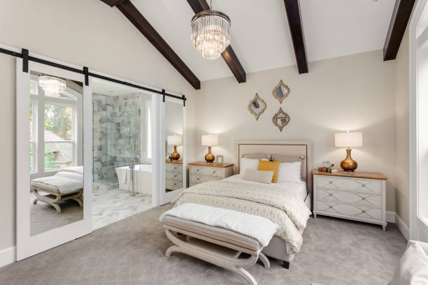 master bedroom in new luxury home with chandelier and view of bathroom - quarto de dormir imagens e fotografias de stock