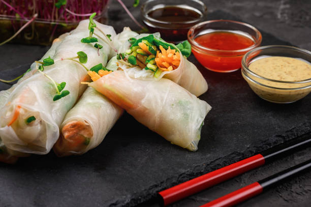 istock On a light background cutting slate board with spring roll. A wholesome Asian appetizer with vegetables and shrimp. Low key photography. 1222627506