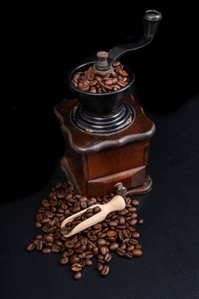 istock Old coffee grinder on the kitchen table. Iconic accessories for brewing black coffee. Dark background. 1222628783