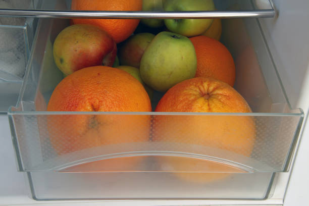 citruses and apples in the refrigerator stock photo