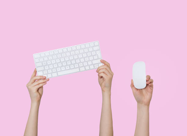 istock Raising hands with keyboard and mouse on purple background 1222631811