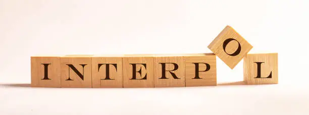 Photo of Interpol - word written on wooden cubes on a light background