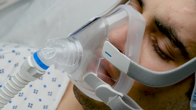 Young man connected to a ventilator mask