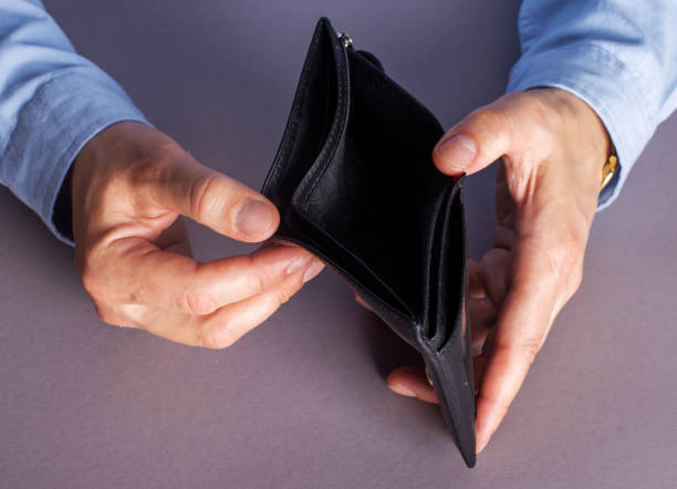 istock In crisis, a man holds an empty wallet in his hands. 1222637456