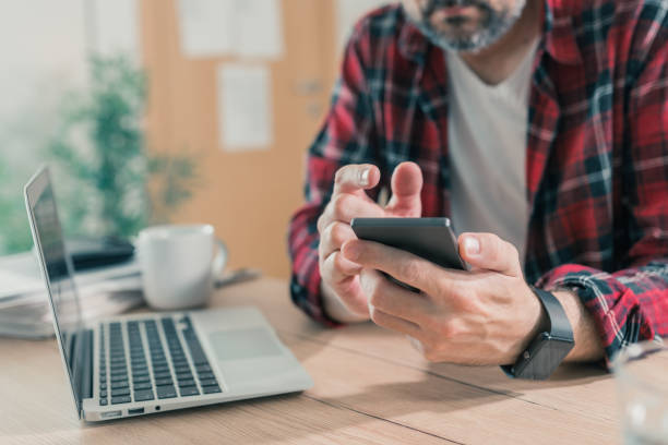 istock Freelancer using mobile phone in home office at the desk 1222637756