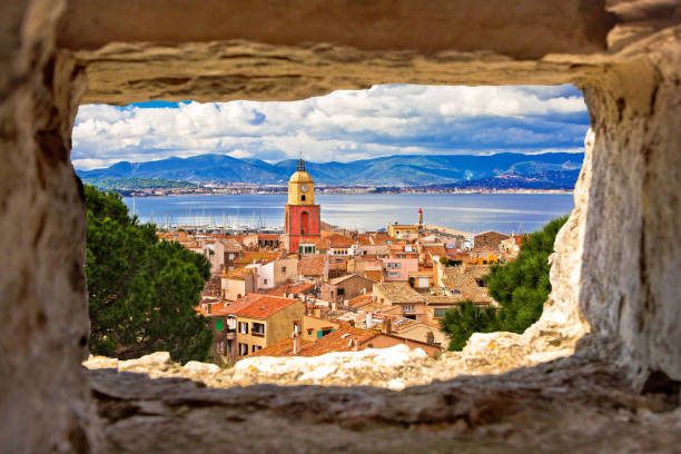 istock Saint Tropez village church tower and old rooftops view through stone window 1222639017