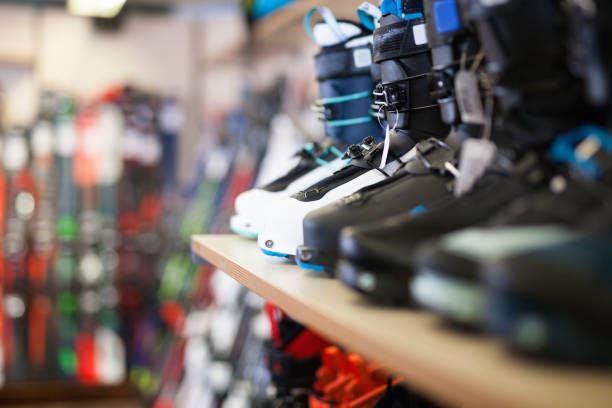 Different  colorful stylish models of boots for alpine skiing on shelves in shop