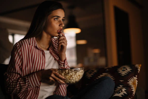 istock Young woman watching tv at home. 1222643631