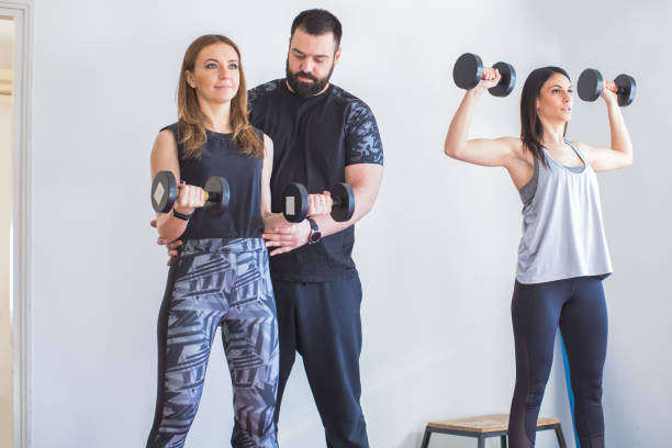 istock two young women exercising at home with personal trainer 1222643655