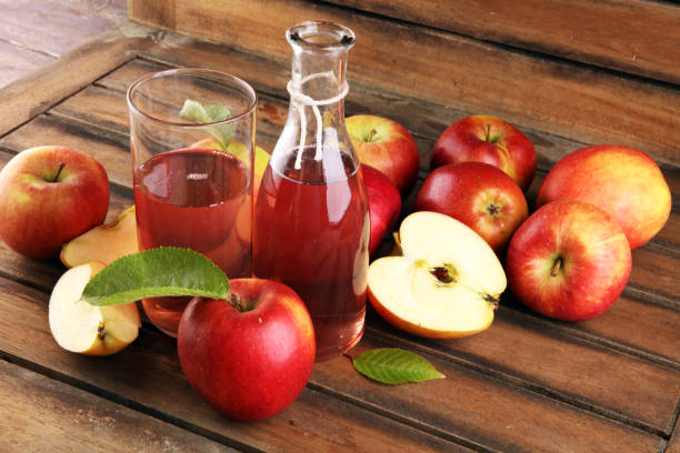 istock Apple cider drink and organic apples with leaves on table 1222647063