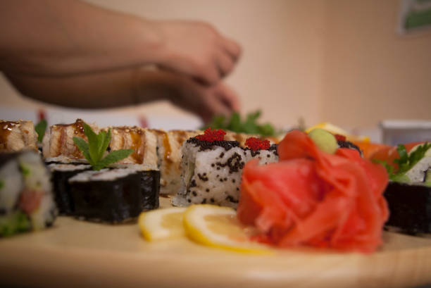 istock decorating sushi rolls close up, food styling 1222650846
