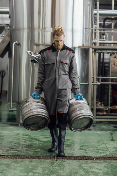 istock Craft Beer Manufacturing: Brewery Worker Carrying Beer Barrels 1222651956