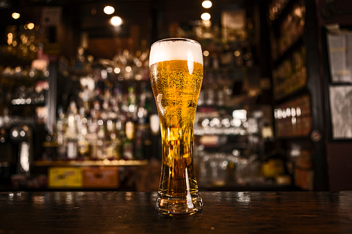 Full glass of poured bear in the bar