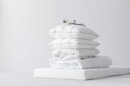 Stack of soft cotton pillows on a mattress (copy space).