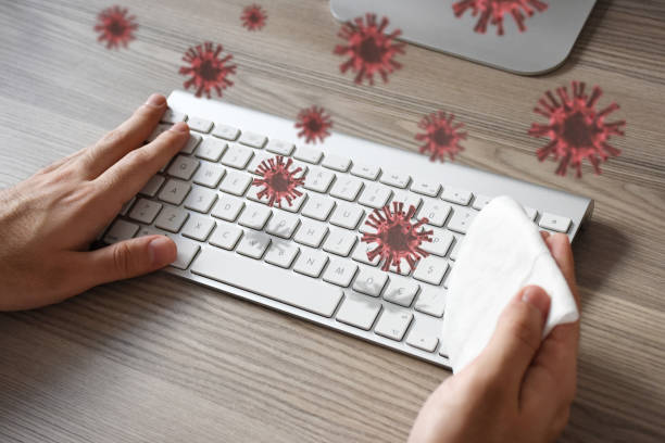 istock Man hands cleaning disinfection computer keyboard on the desk with coronavirus, COVID-19 1222654123