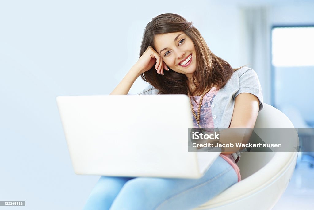 Woman with an attractive smile using laptop  20-29 Years Stock Photo