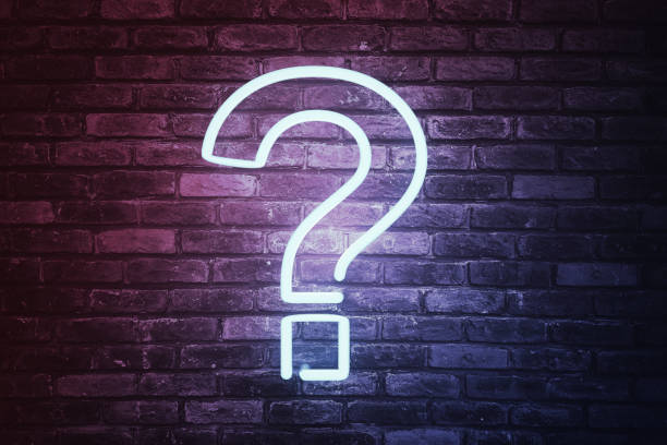 istock 3D illustrated question mark with led light on brick wall background. 1222658355