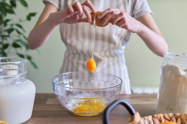 nahaufnahme des brechens eines eis in der schüssel, die zubereitung von teig für pfannkuchen - chicken egg flash stock-fotos und bilder