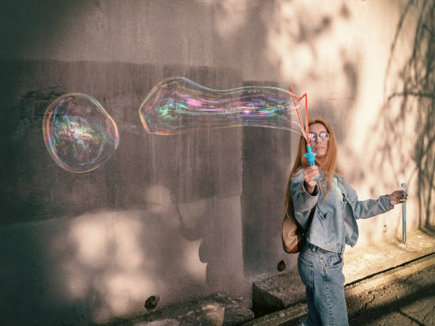istock Girl launches beautiful soap bubbles on the street 1222660321