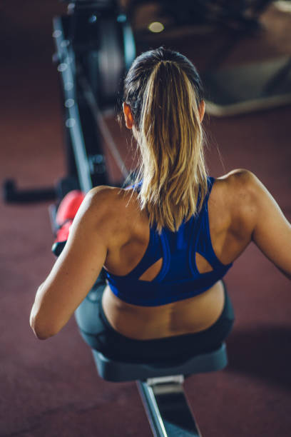 istock Fit female athlete training on rowing machine at the gym 1222667877