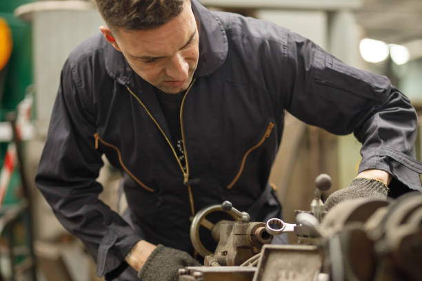 istock Close up engineering industrial worker is working on metal work factory process performing mechanical turning operation at machine. 1222668189