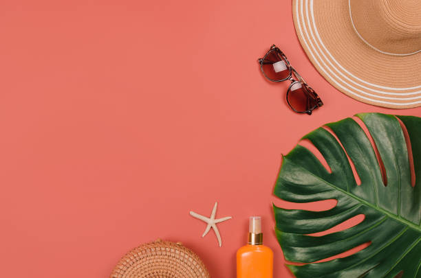 istock Summer straw hat, tropical monstera leaf, sunglasses, shells, suncream, starfish on red background. 1222668890
