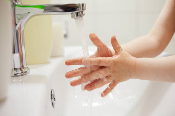 2 year old baby boy washes his hands with soap in the bathroom - baby beautiful part of selective focus imagens e fotografias de stock