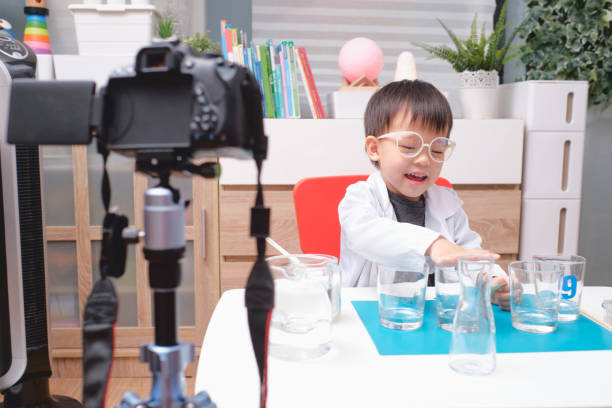 garçon asiatique faisant des expériences de chimie et enregistrant une vidéo pour ses disciples, jeune enfant blogueur posant devant la caméra, enfants font vlog pour le concept de canal de médias sociaux - toy camera photos et images de collection