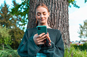 Confident Smile. Young Woman on Mobile Phone