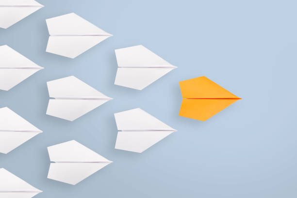 istock Leadership concepts with orange paper airplane leading among white 1222671185