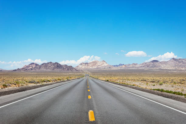 Open Highway Route 95 Nevada USA Middle of the Road, Open Highway Route 95 towards Lone Mountain - Tonopah. Truck with illuminated front lights on the highway horizon. Nevada, USA, North America nevada highway stock pictures, royalty-free photos & images