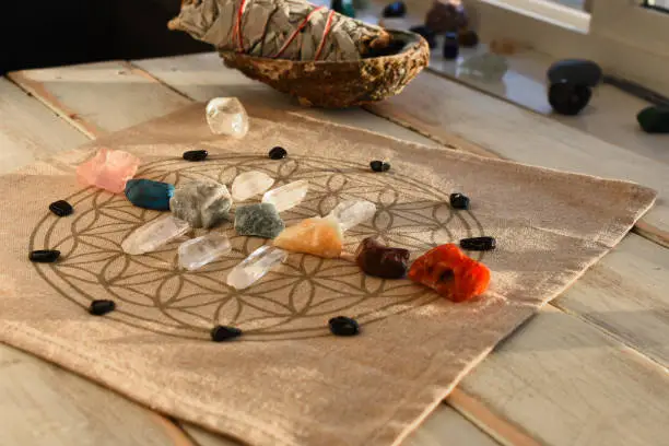 An close up image of chakra balancing crystals on a wooden table with the glowing evening sunlight warming the crystals.