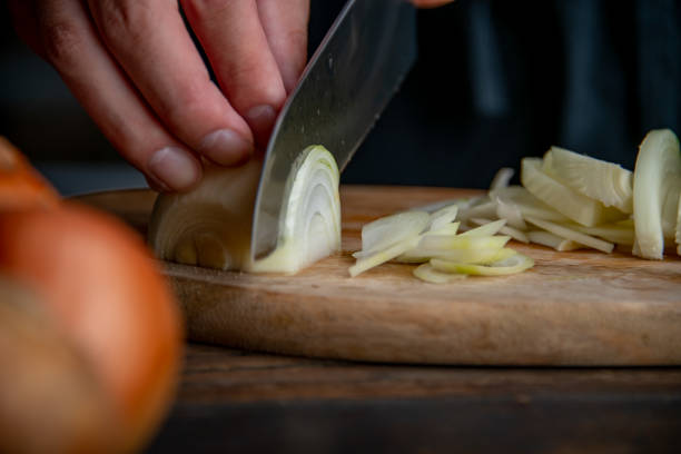 istock Slicing onion on cutting board in kitchen. Cooking image. 1222683986