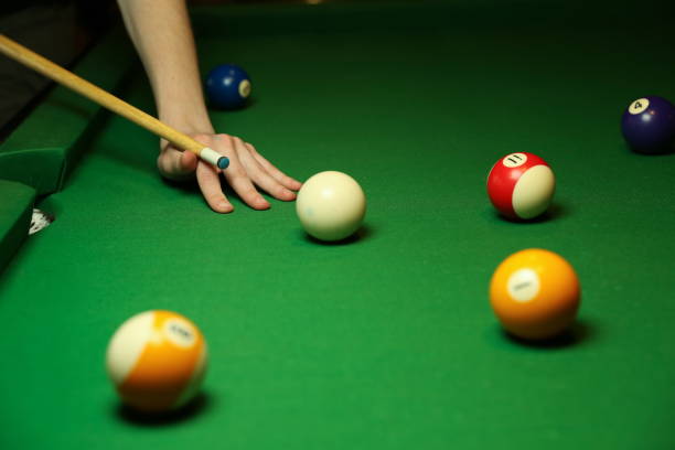 istock the hand of a billiard player holds a cue on a pool table. 1222690584