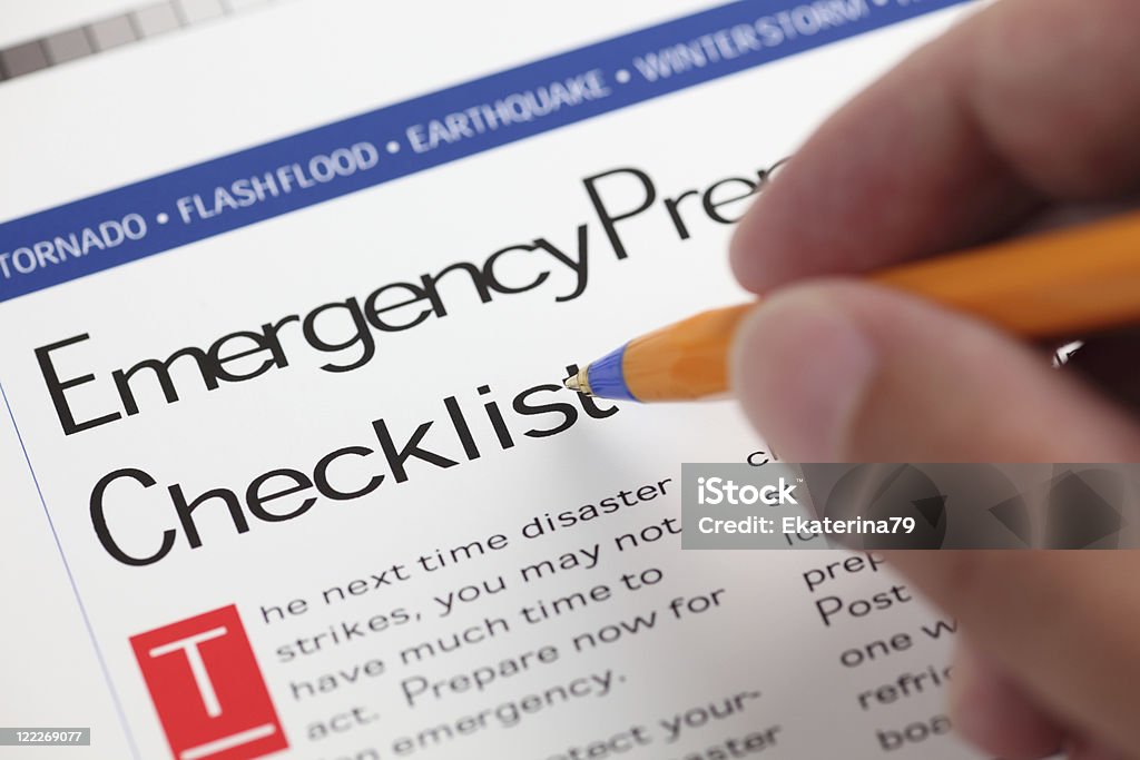 Emergency Checklist Emergency Checklist and hand with ballpoint pen. Close-up. Accidents and Disasters Stock Photo